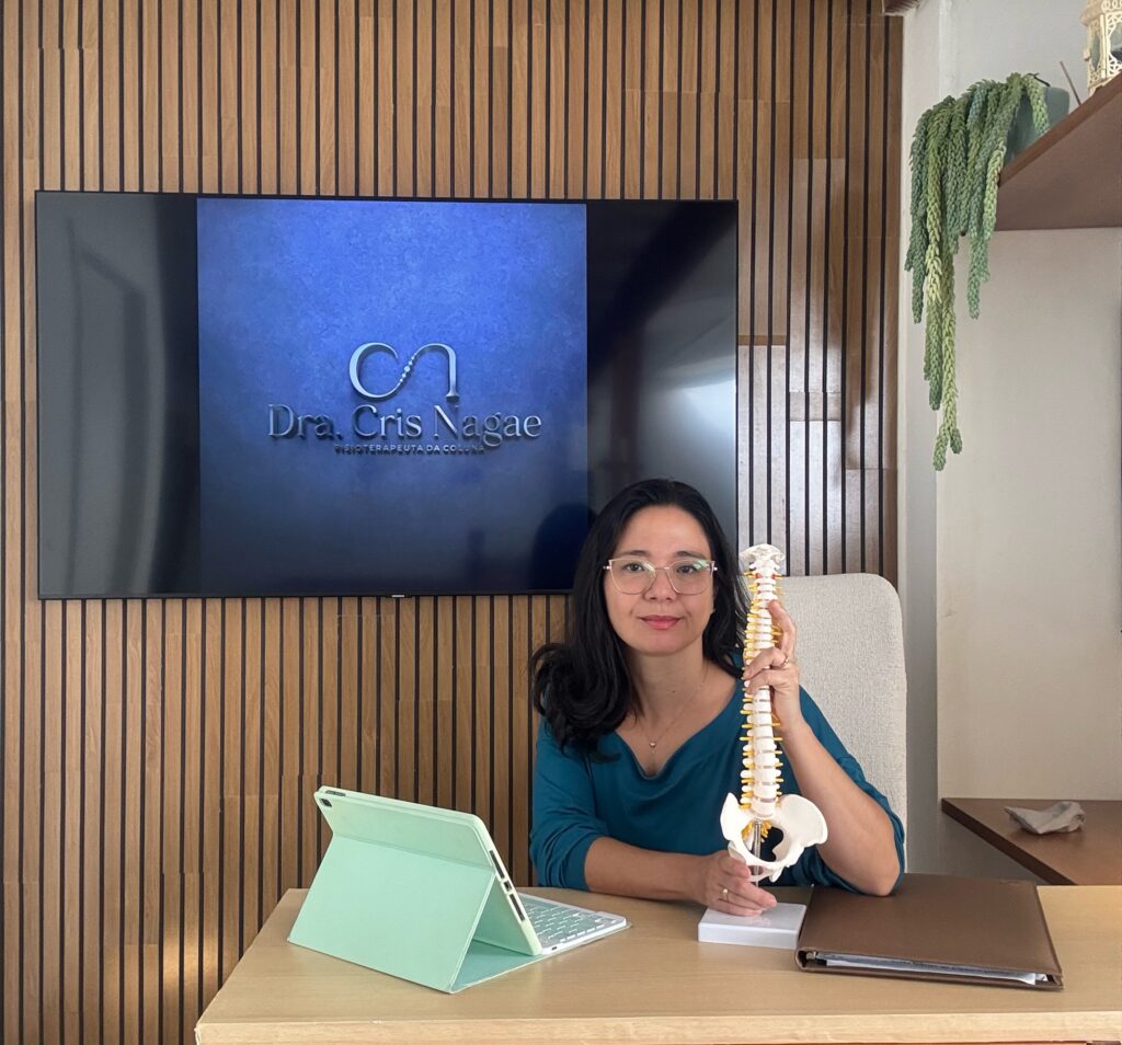 Dra Cris Nagae sentada em seu consultório de atendimento online